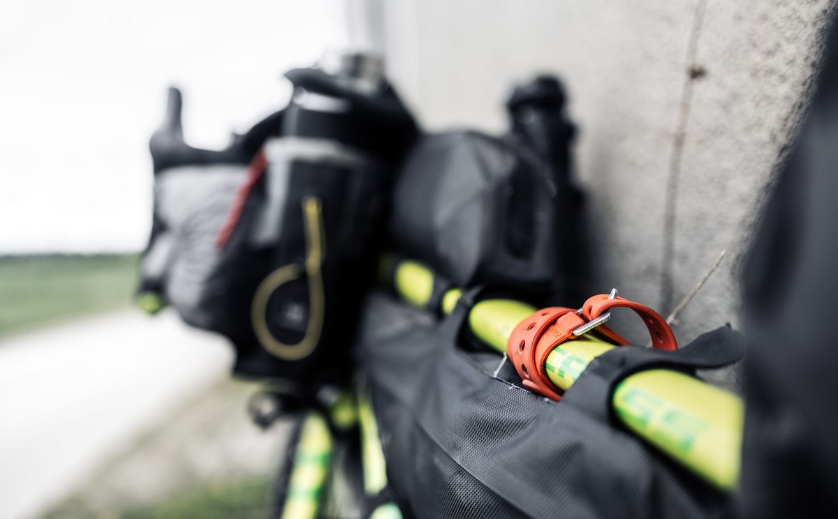 Détail d'un équipement de bivouac avec sac à dos et cordes de fixation jaunes et rouges