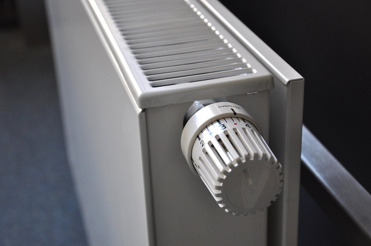 Radiateur blanc de chauffage avec robinet thermostatique en gros plan, équipement domestique