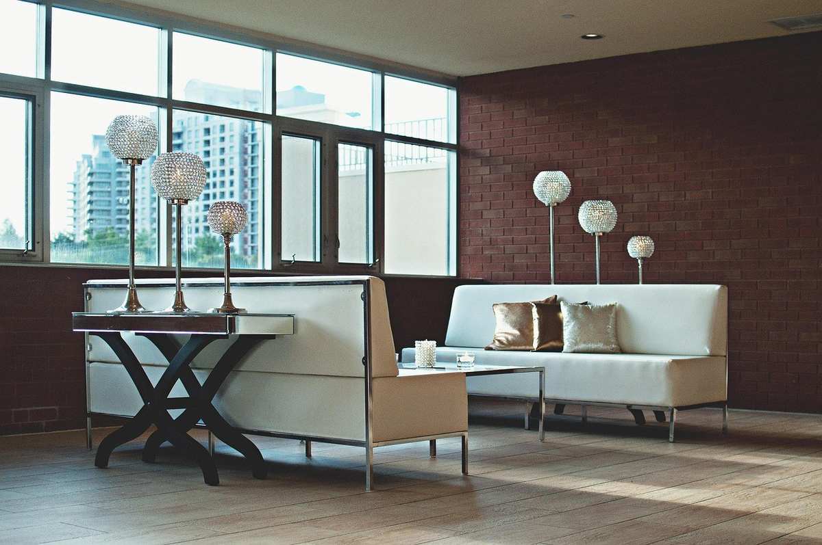 Salle de réunion avec canapés, tables, lampes, et vue sur des immeubles par des fenêtres Salle de réunion avec canapés, tables, lampes, et vue sur des immeubles par des fenêtres