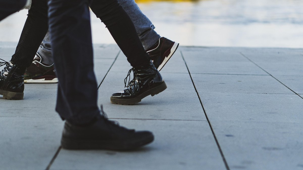 Une paire de chaussures de marche et une veste légère posées sur un lit