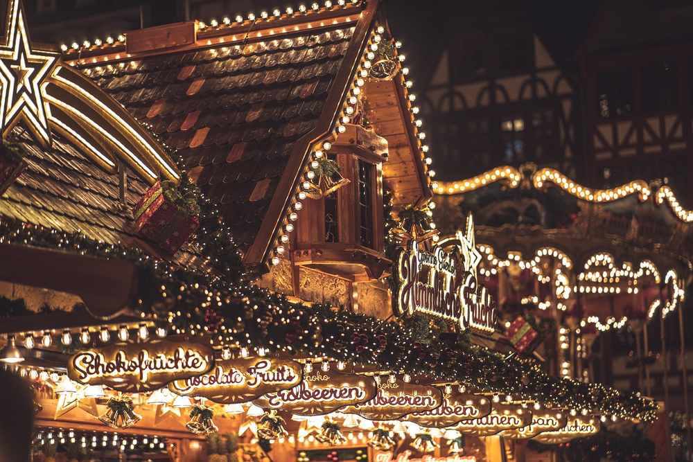 Marché de Noël alsacien avec maison à colombages illuminée de guirlandes lumineuses