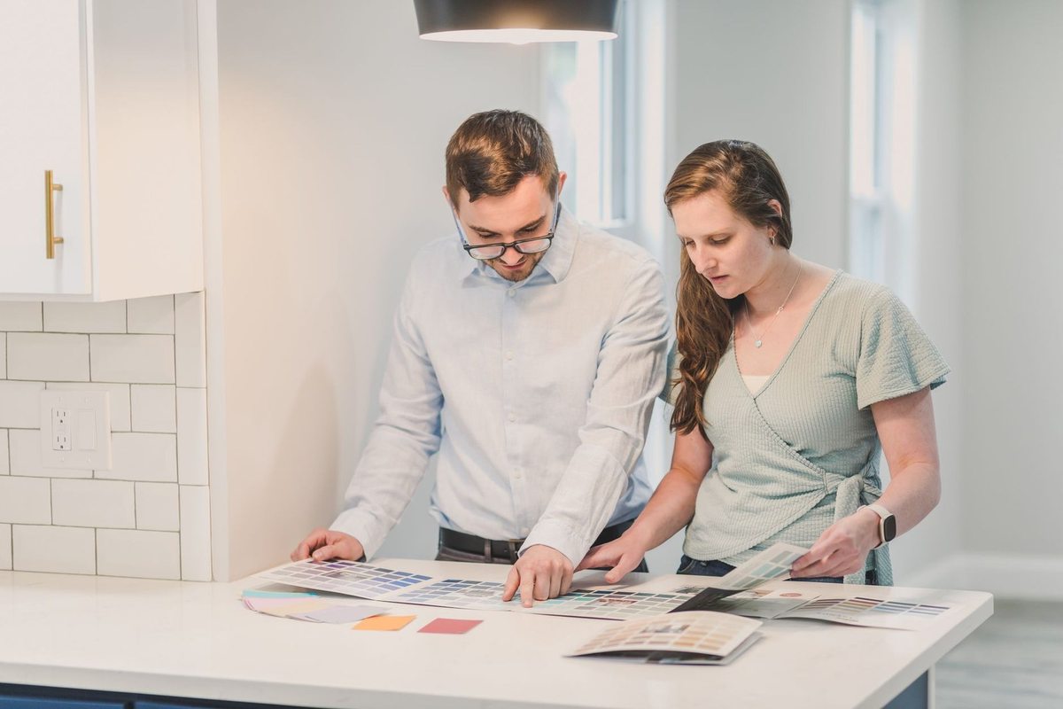 Homme et femme &eacute;tudient des papiers &agrave; une table de cuisine