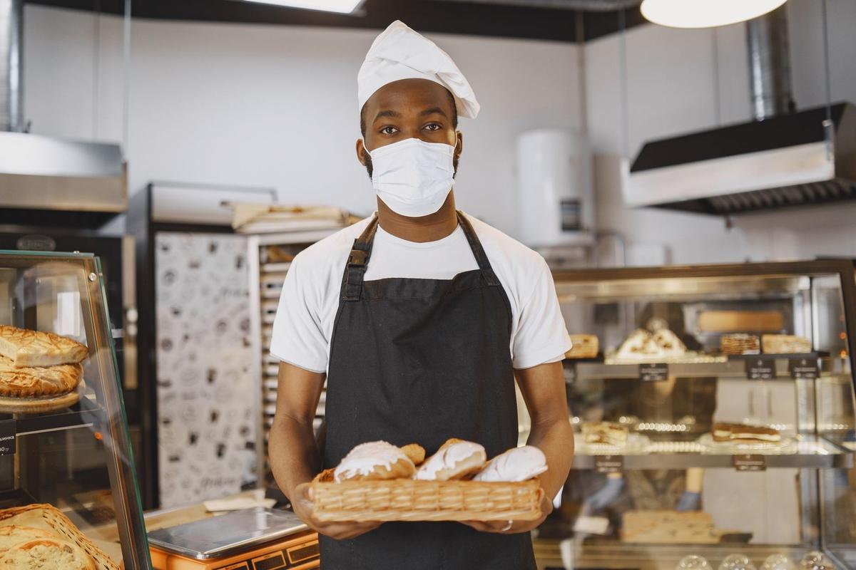 Boulanger présentant des pâtisseries dans une vitrine de boulangerie