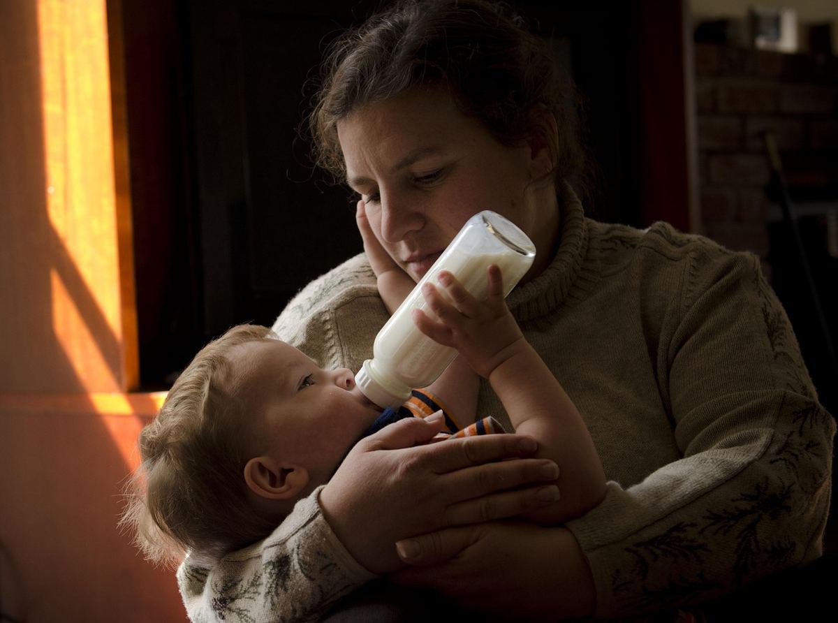 Une femme allaite son enfant en le tenant contre elle Une femme allaite son enfant en le tenant contre elle