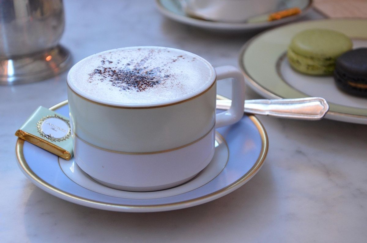 Tasse de café avec macarons sur une table en marbre