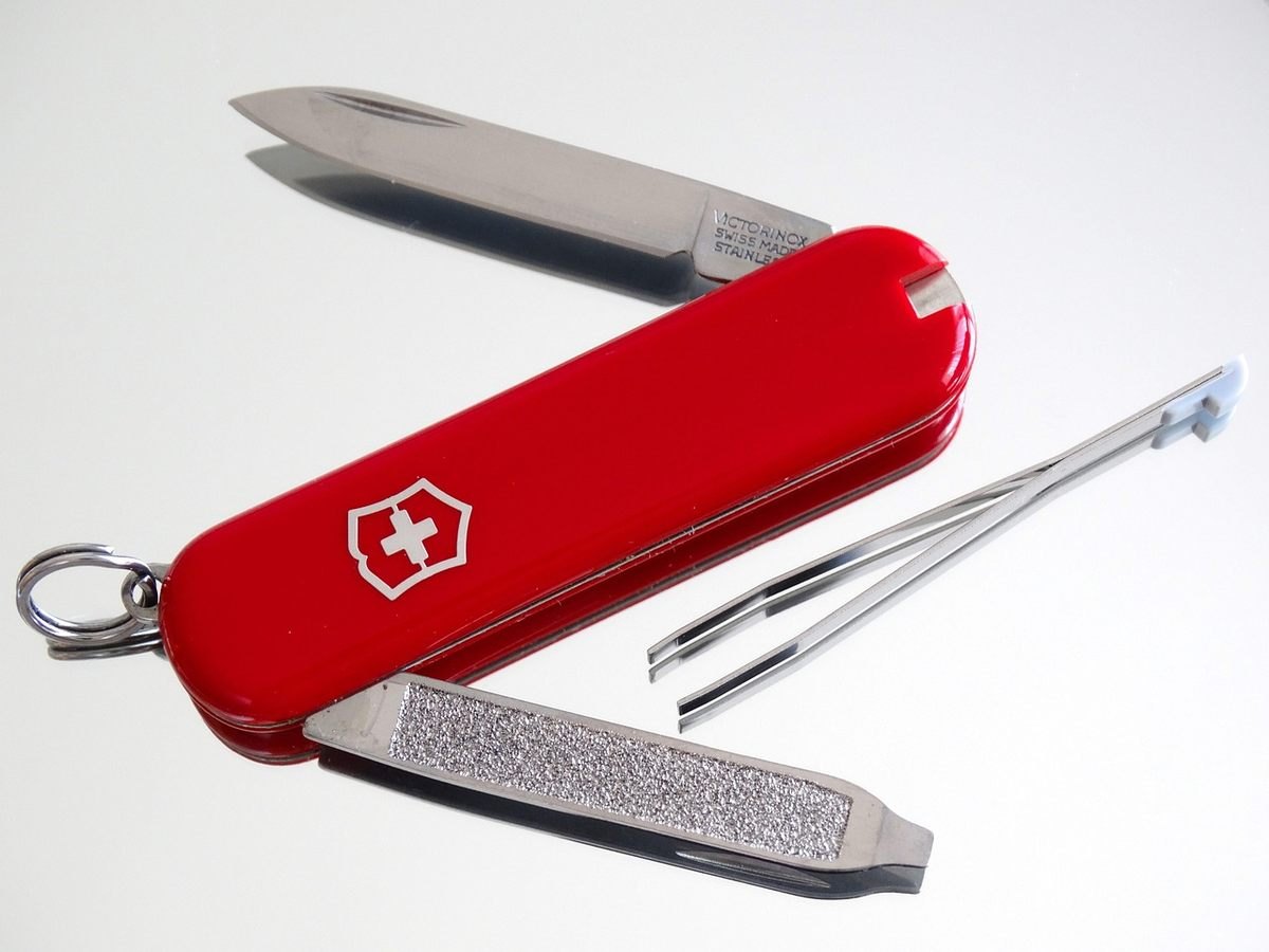 Couteau suisse rouge déplié montrant lame, lime et autres outils Couteau suisse rouge déplié montrant lame, lime et autres outils