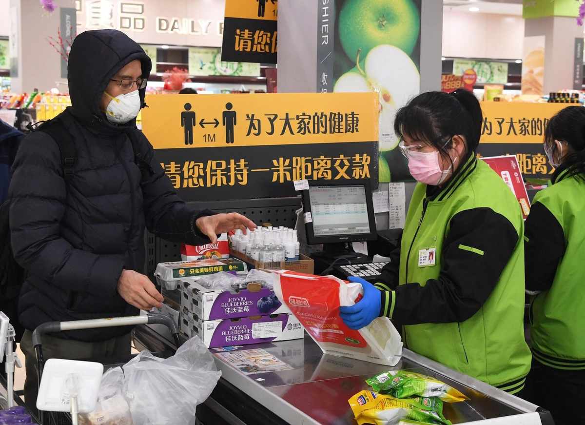 Personnes portant des masques dans un supermarché pendant des achats Personnes portant des masques dans un supermarché pendant des achats