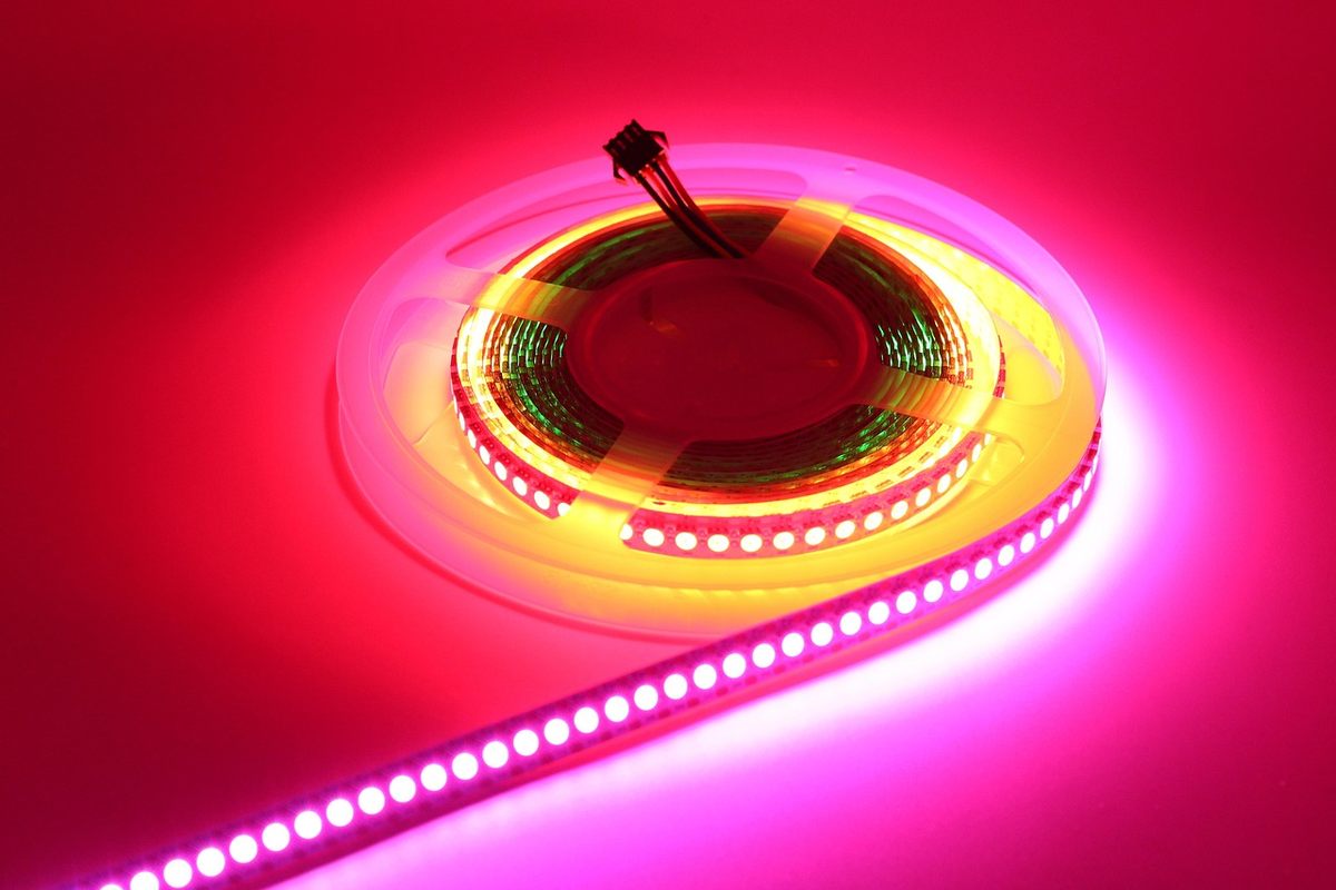 Gros plan d'un ruban LED blanc chaud fixé derrière un moniteur