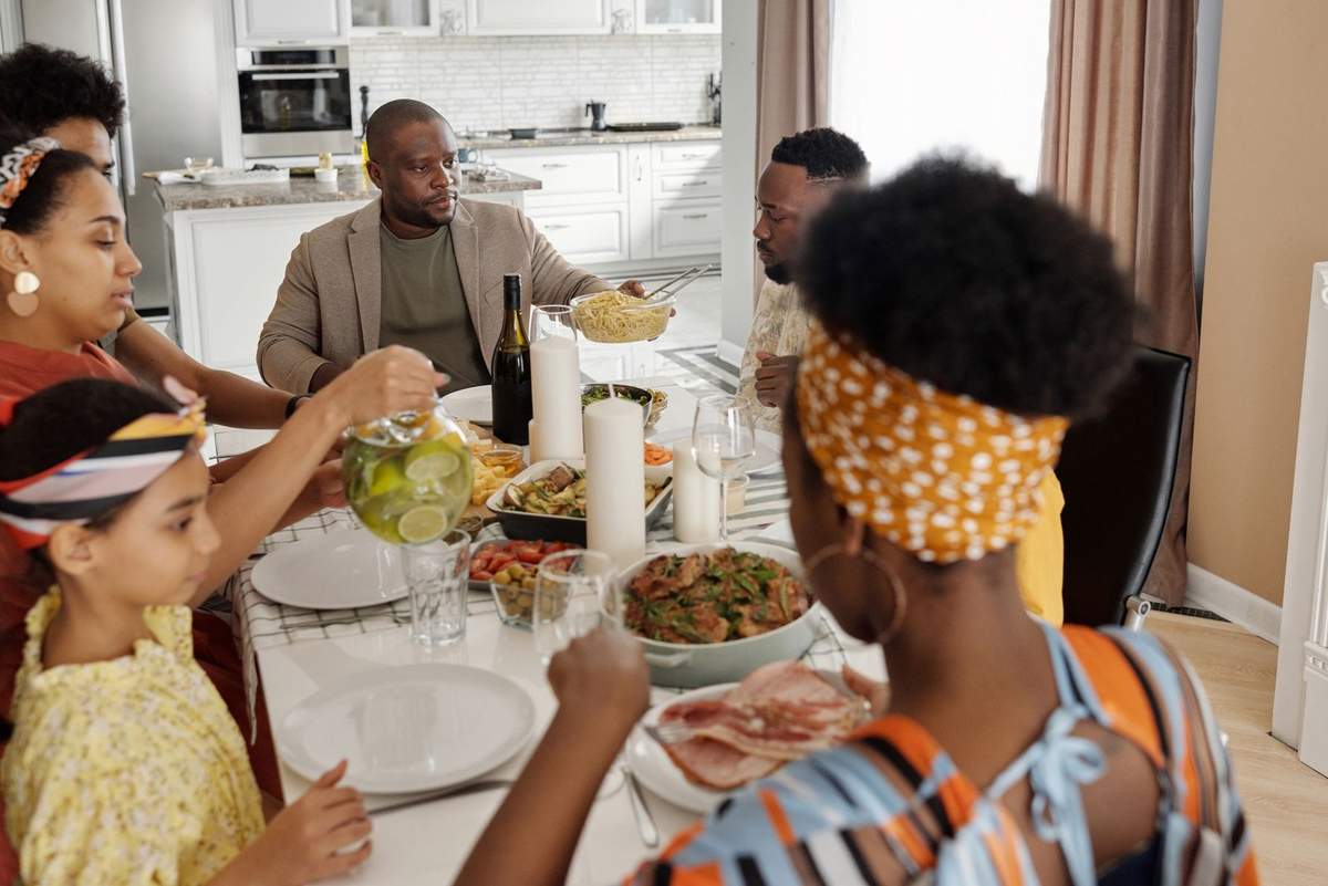 Famille diverse déjeune ensemble dans une cuisine lumineuse