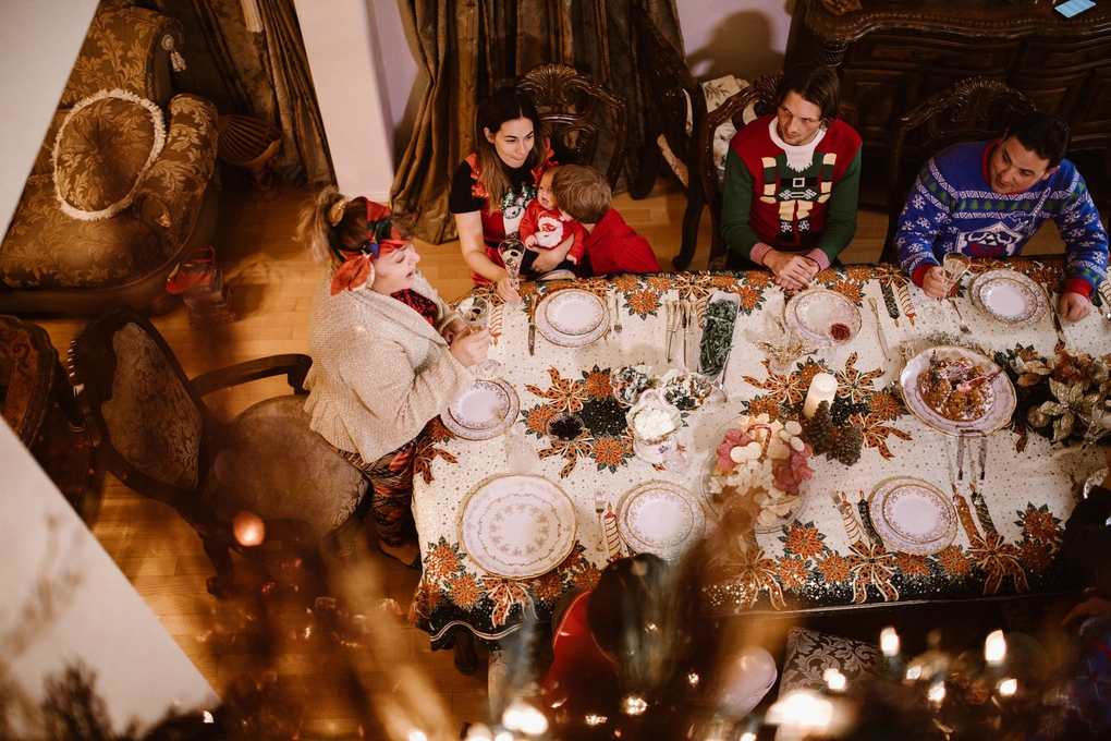 Famille réunie autour d'une table de Noël, assiette, bougie, décoration, repas en cours Famille réunie autour d'une table de Noël, assiette, bougie, décoration, repas en cours