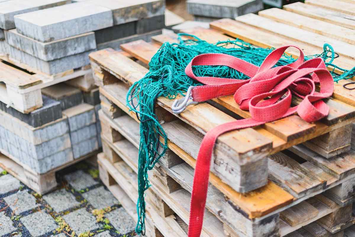 Palettes de bois empilées avec une corde turquoise et un ruban rouge noué autour Palettes de bois empilées avec une corde turquoise et un ruban rouge noué autour