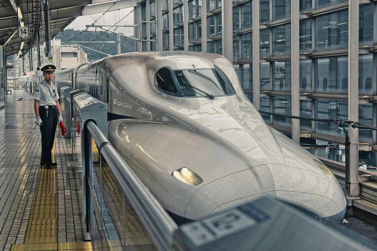 Train de passagers blanc brillant en gare, voyageur sur le quai Train de passagers blanc brillant en gare, voyageur sur le quai