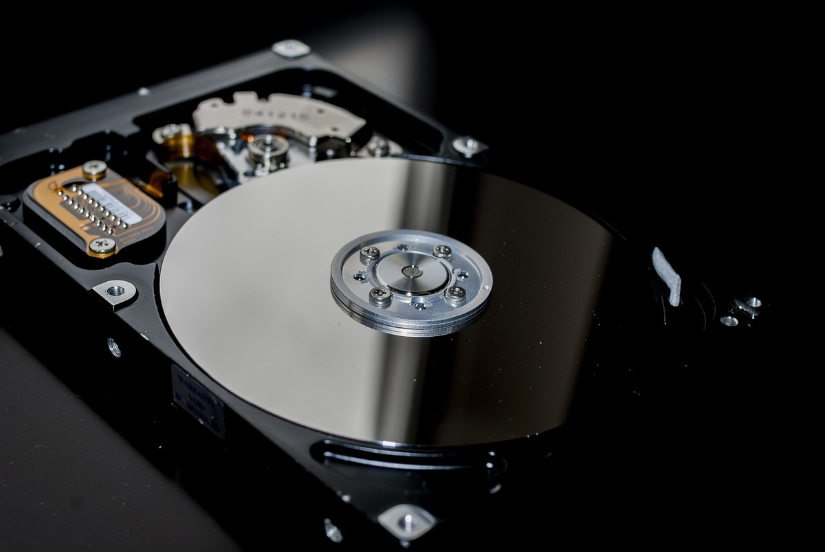 Un disque SSD posé à côté d’un ancien disque dur de PC portable Un disque SSD posé à côté d’un ancien disque dur de PC portable