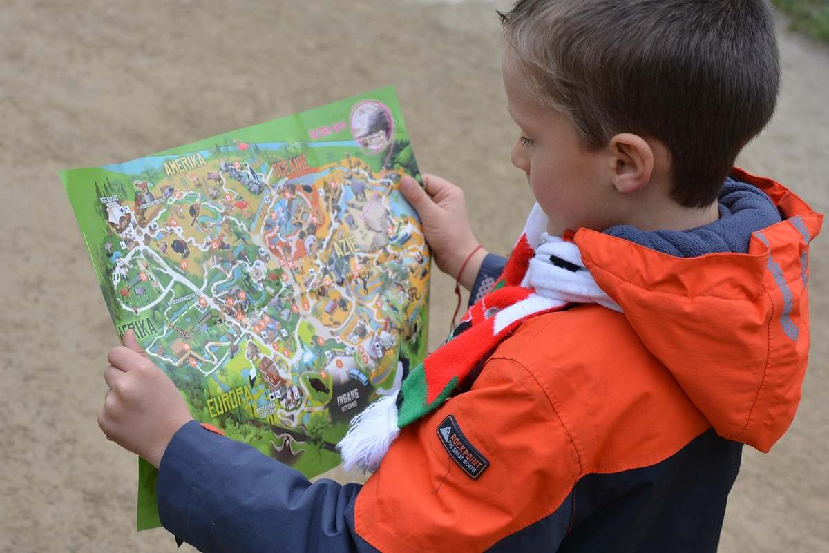 Une famille observe une carte de randonnée en pleine nature
