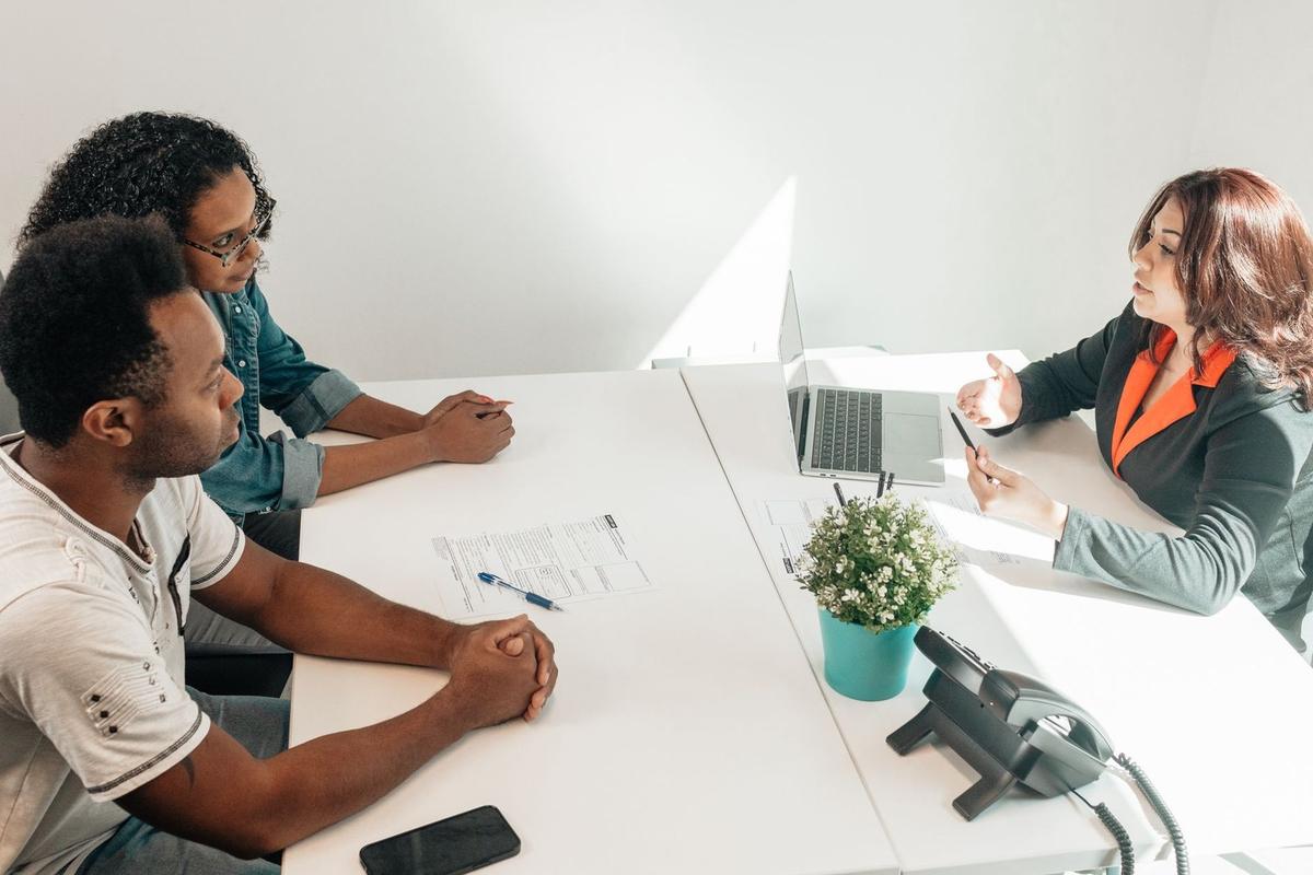 Réunion professionnelle autour d'une table blanche avec ordinateur et téléphone