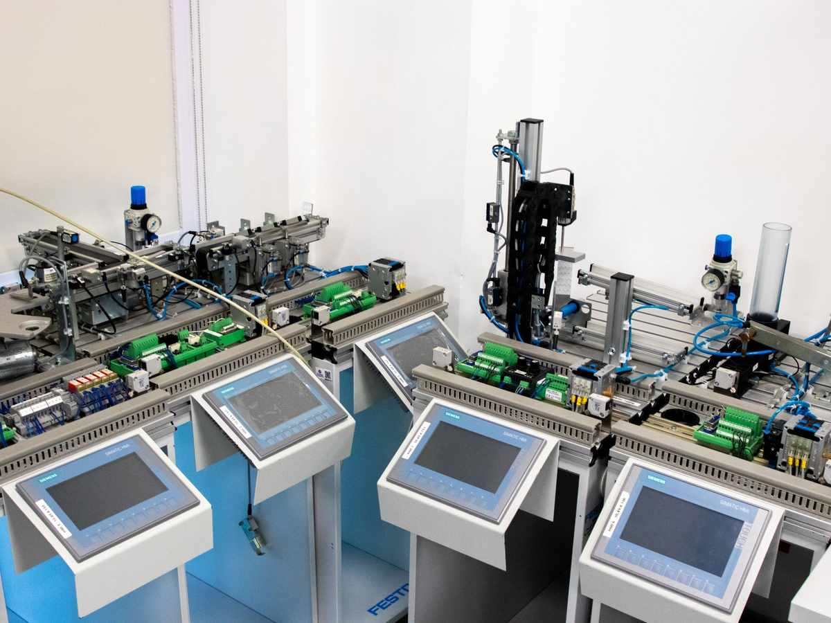 Vue d'une chaîne de production automatisée avec écrans tactiles et bras robotique