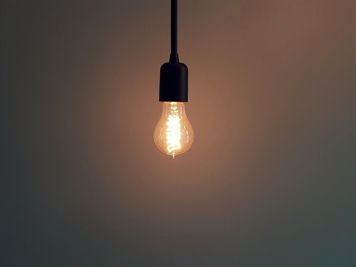Ampoule vintage incandescente allumée, suspendue par un fil noir