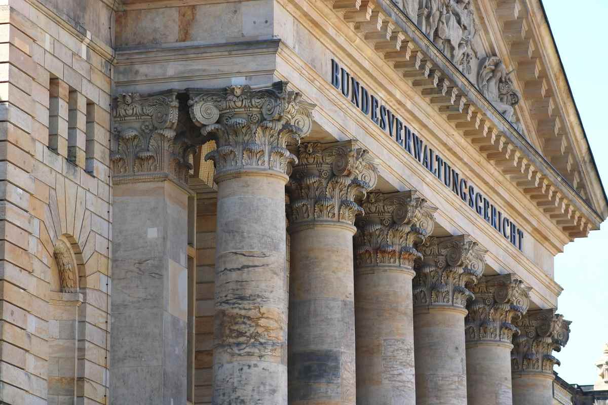 Façade de palais de justice avec colonnes corinthiennes et inscription institutionnelle bleue