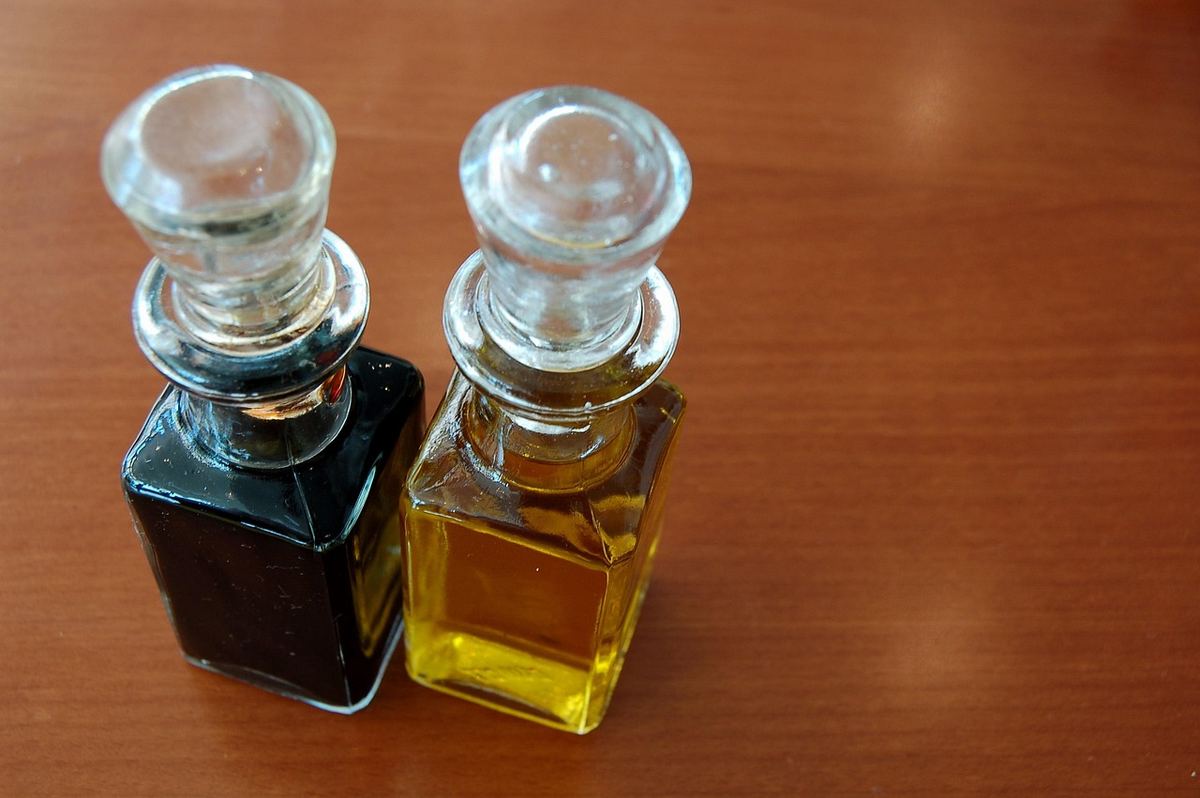 Du vinaigre blanc et du gros sel utilisés pour nettoyer une planche en bois Du vinaigre blanc et du gros sel utilisés pour nettoyer une planche en bois