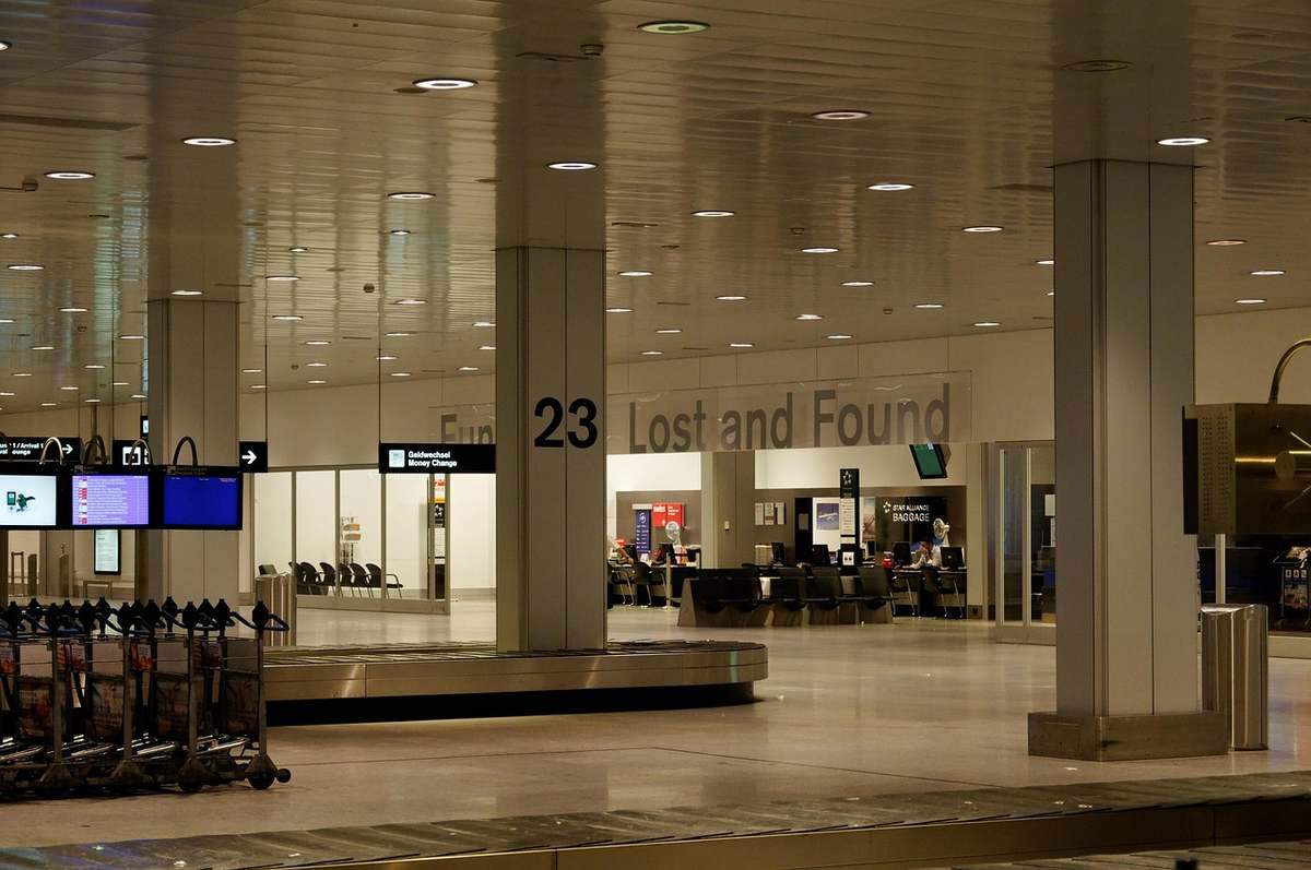 Intérieur d'un aéroport avec des colonnes, des écrans et une zone de recherche d'objets perdus