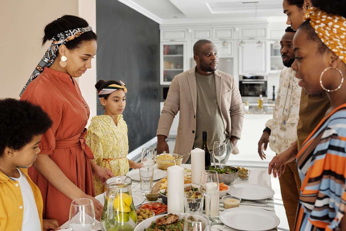Famille diverse cuisinant et partageant un repas dans une cuisine lumineuse Famille diverse cuisinant et partageant un repas dans une cuisine lumineuse