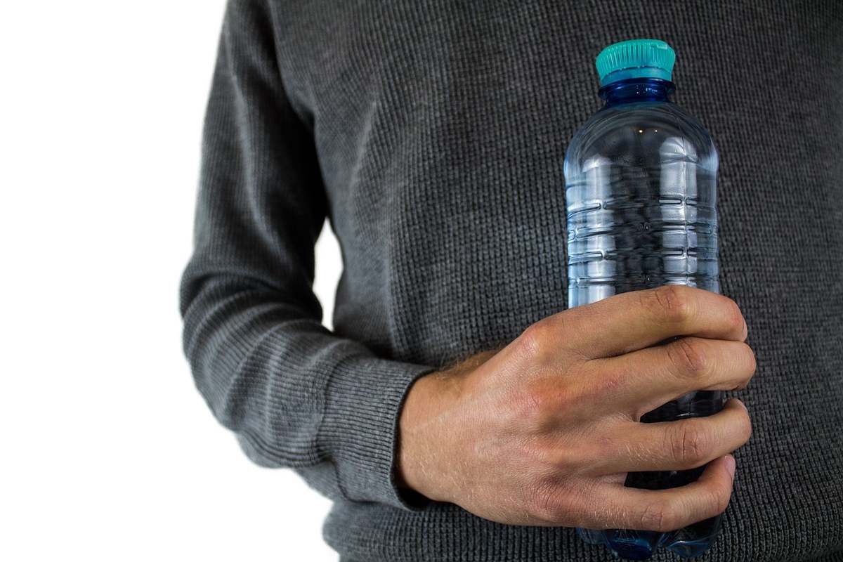 Randonneur avec une gourde et un sac d'hydratation en montagne