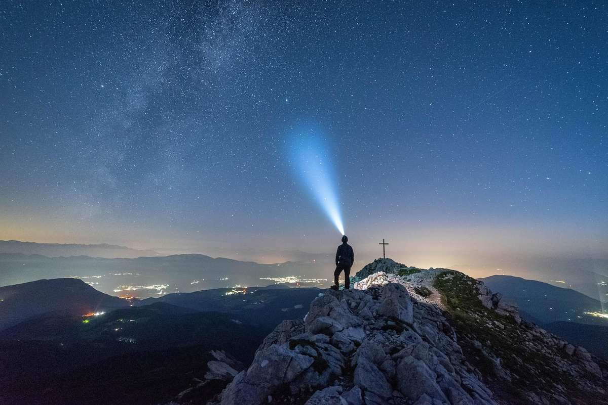 Lampe frontale allumée posée sur une table de camping