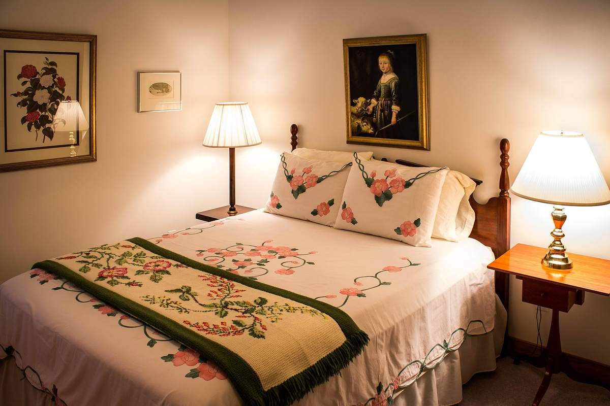Chambre d'hôte décorée avec lits douillets, lampes de chevet allumées, tableaux muraux Chambre d'hôte décorée avec lits douillets, lampes de chevet allumées, tableaux muraux