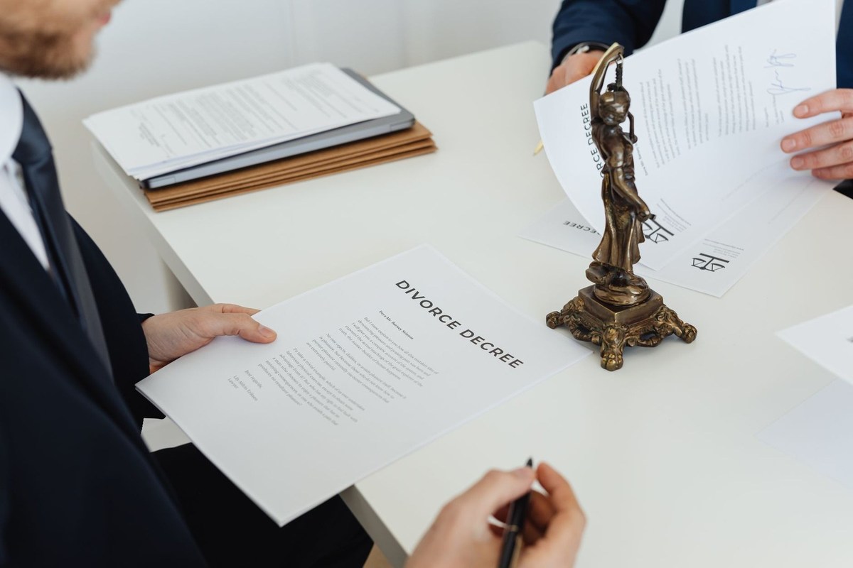 Individus en réunion professionnelle signant des papiers avec un trophée sur la table Individus en réunion professionnelle signant des papiers avec un trophée sur la table