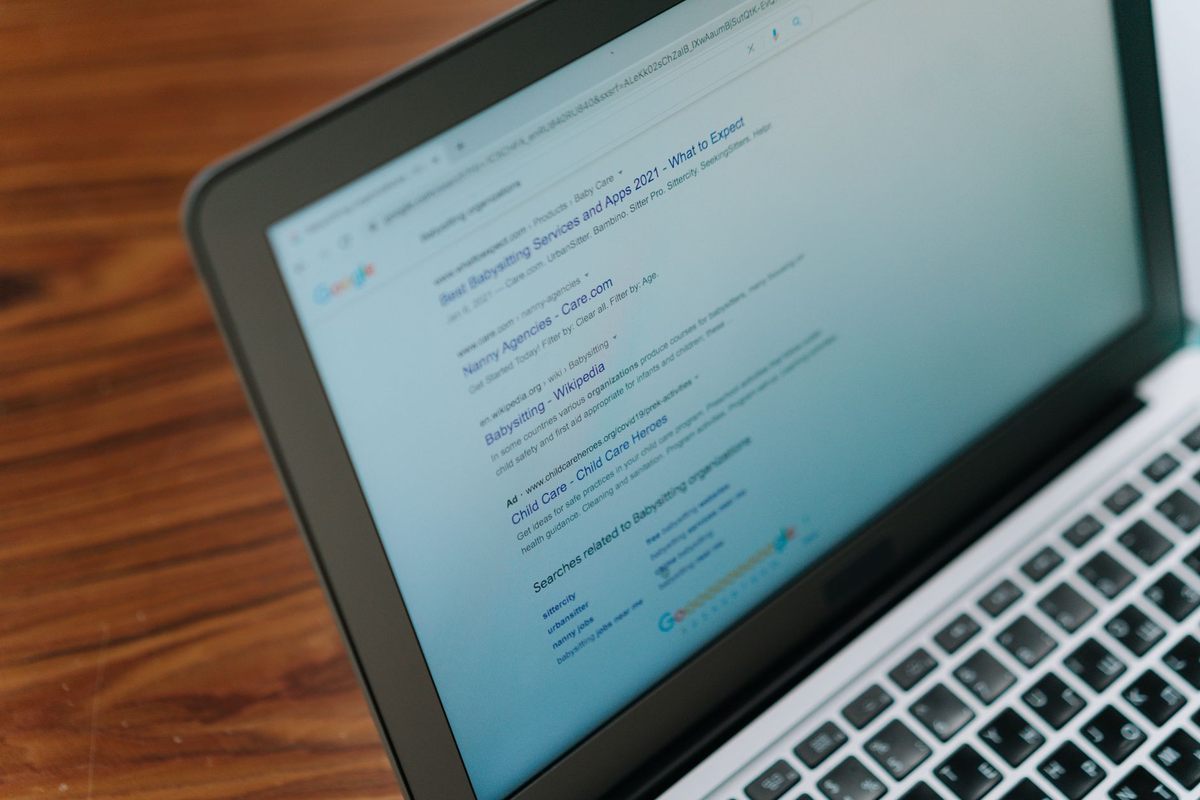 Ordinateur portable affichant du contenu textuel, posé sur un bureau en bois