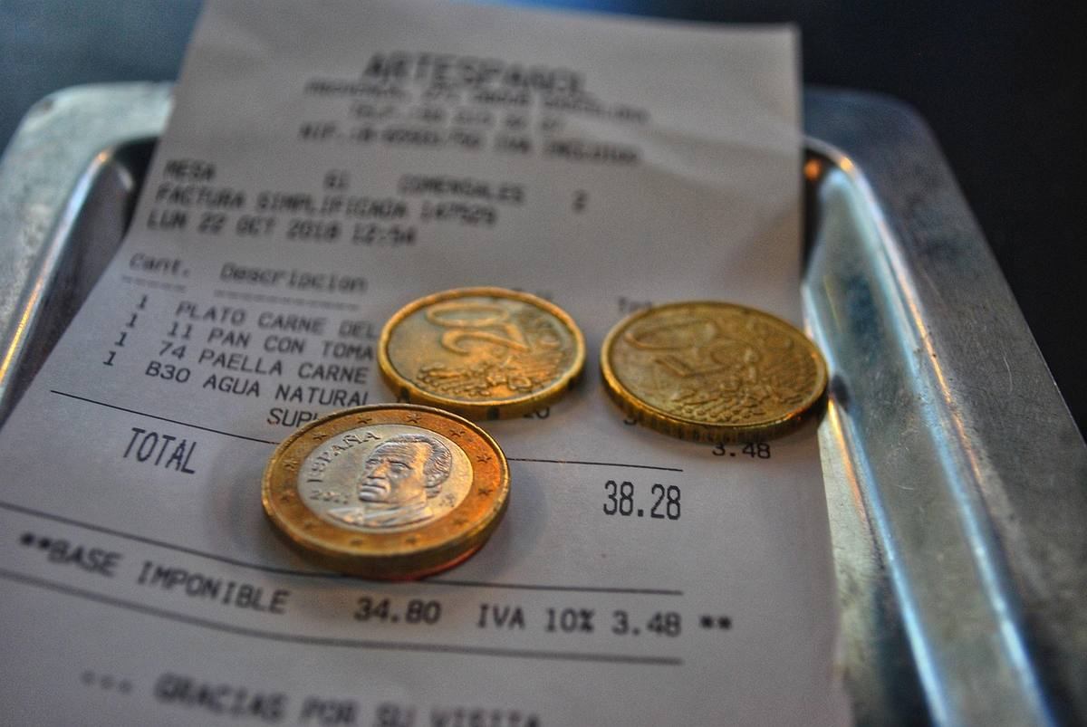 Un reçu, trois pièces et une assiette métallique sur plateau Un reçu, trois pièces et une assiette métallique sur plateau